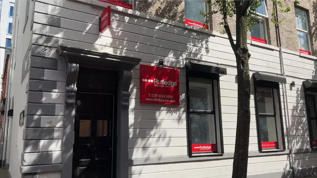 Rutledge Recruitment & Training Belfast branch, grey rendered Georgian building with a red Rutledge sign beside a black panelled doorway.