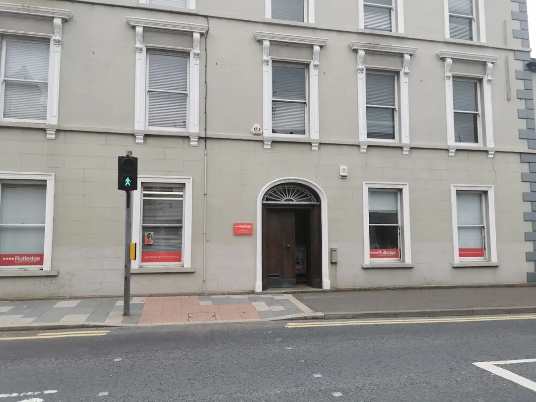 Rutledge Recruitment & Training Downpatrick branch, sage-grey Georgian terrace with arched panelled doorway and red Rutledge window signage.